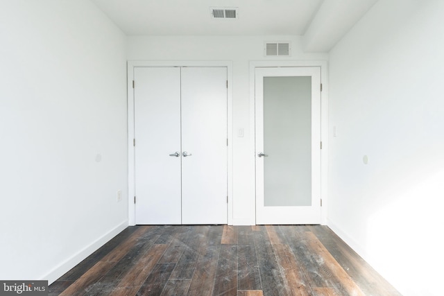 unfurnished bedroom with dark hardwood / wood-style floors