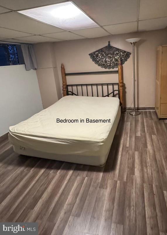 bedroom with a paneled ceiling and hardwood / wood-style flooring