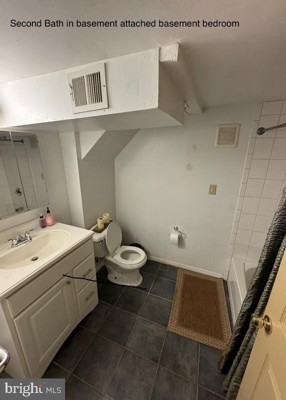 full bathroom featuring tile patterned flooring, vanity, toilet, and tiled shower / bath combo