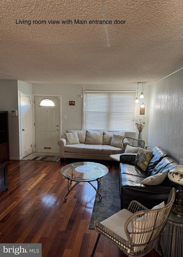 living room featuring a textured ceiling and dark wood-type flooring