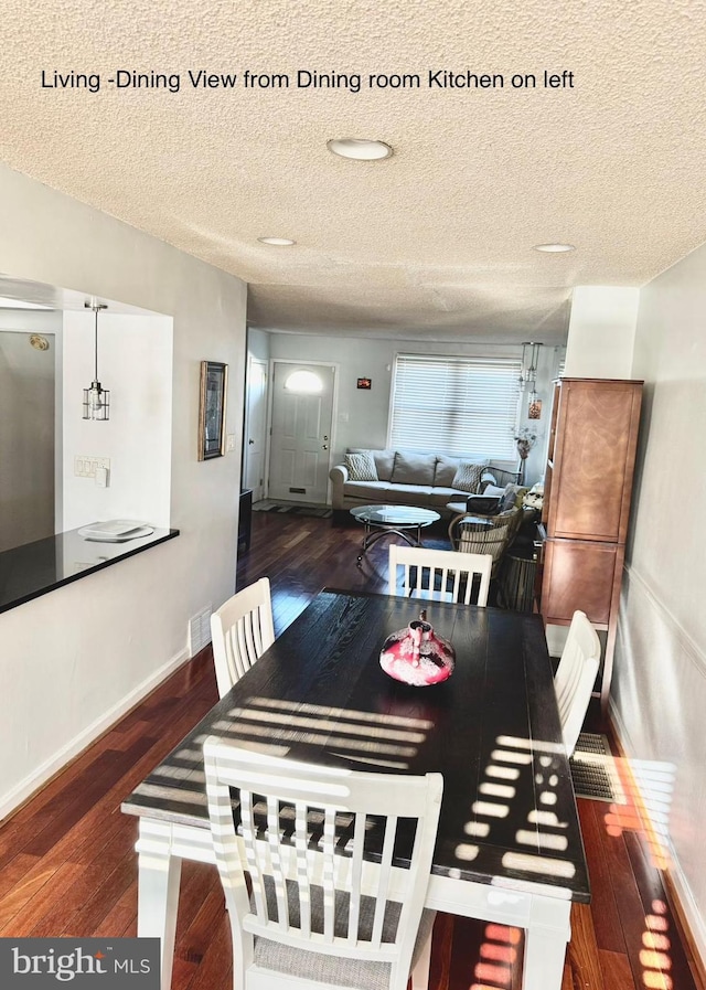 dining space with a textured ceiling and dark hardwood / wood-style floors