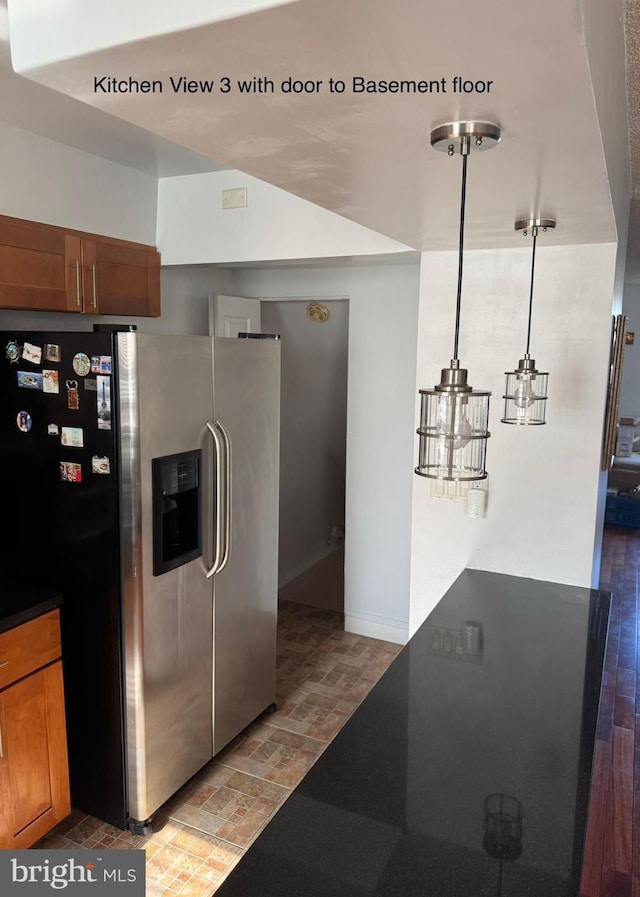 kitchen with stainless steel fridge, hanging light fixtures, and light hardwood / wood-style flooring