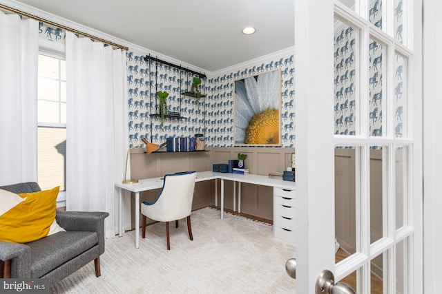 office area with light colored carpet, built in desk, and ornamental molding