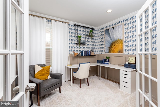 carpeted home office featuring french doors, built in desk, and ornamental molding