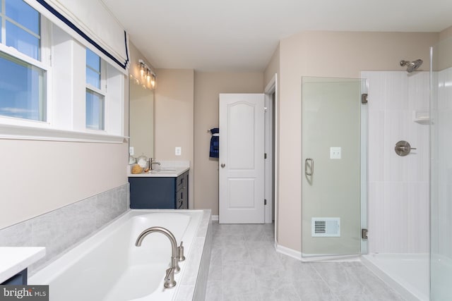 bathroom with tile patterned floors, vanity, and separate shower and tub