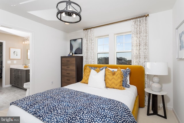 tiled bedroom featuring connected bathroom and an inviting chandelier