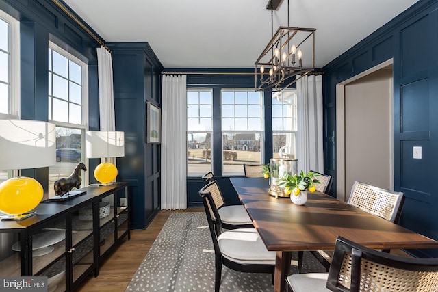 dining area with a wealth of natural light, dark hardwood / wood-style flooring, and a notable chandelier