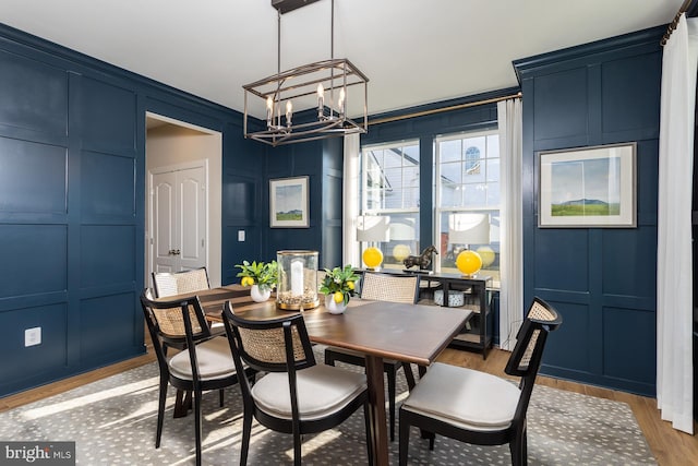 dining room with wood-type flooring, a notable chandelier, and ornamental molding