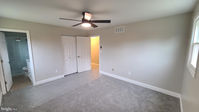 unfurnished bedroom with a closet, ensuite bathroom, and ceiling fan