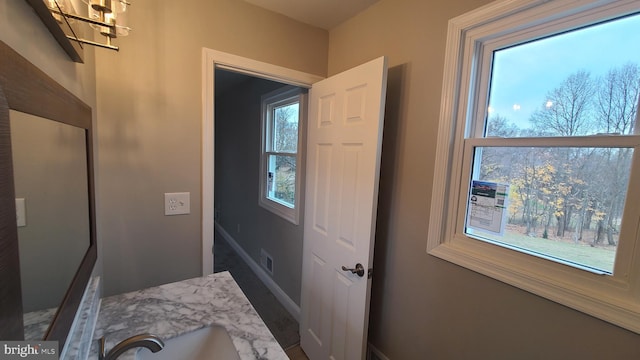 doorway featuring sink and an inviting chandelier