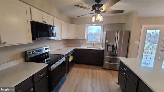 kitchen featuring light stone counters, stainless steel appliances, sink, light hardwood / wood-style flooring, and white cabinetry