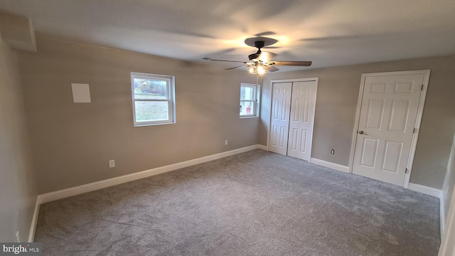 unfurnished bedroom featuring ceiling fan, carpet floors, and two closets