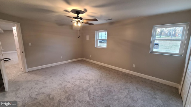 spare room featuring a wealth of natural light, ceiling fan, and light carpet