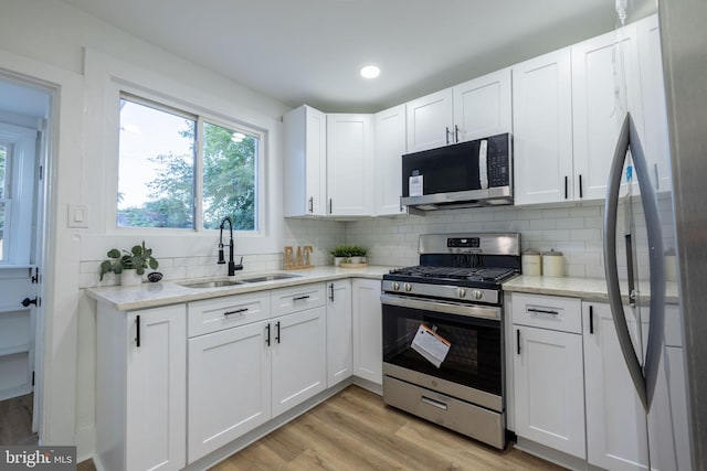 kitchen with sink, white cabinetry, and stainless steel appliances