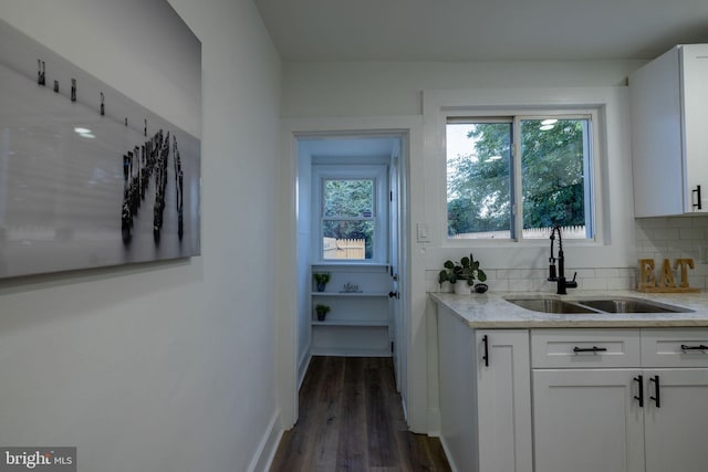 bar with tasteful backsplash, white cabinetry, and dark wood-type flooring