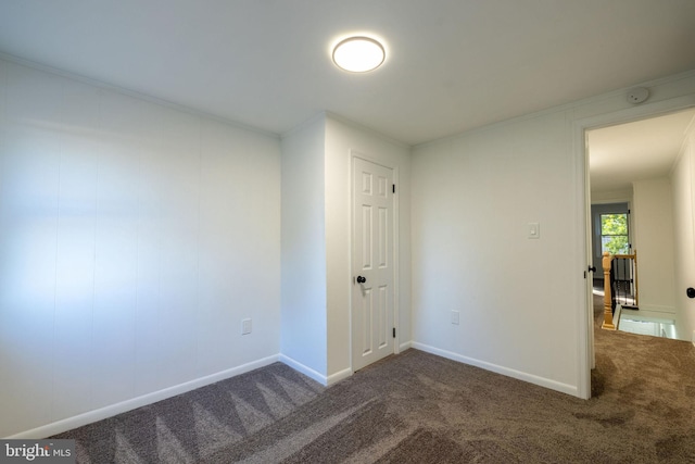 unfurnished room with dark carpet