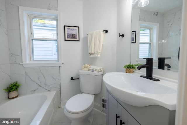 bathroom with vanity, a healthy amount of sunlight, toilet, and a tub