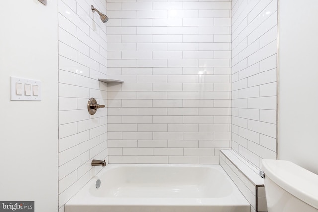 bathroom with tiled shower / bath combo and toilet