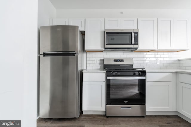 kitchen with white cabinets, dark hardwood / wood-style floors, and appliances with stainless steel finishes