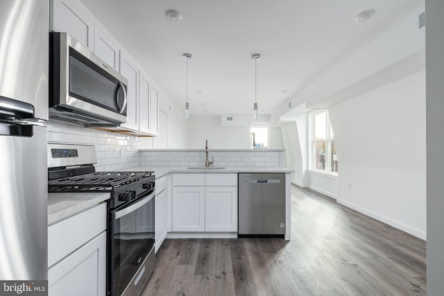 kitchen with white cabinets, appliances with stainless steel finishes, dark wood-type flooring, and sink