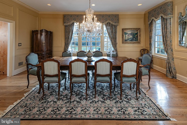 dining space featuring crown molding, light hardwood / wood-style floors, and a notable chandelier