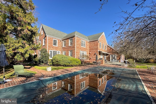 back of house featuring a patio area and a covered pool