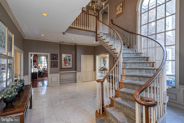 stairway with a high ceiling and ornamental molding