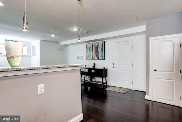 kitchen featuring hanging light fixtures and dark wood-type flooring