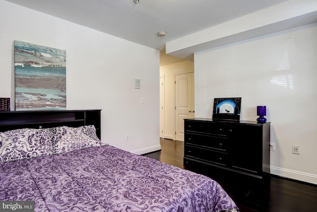 bedroom with dark hardwood / wood-style floors