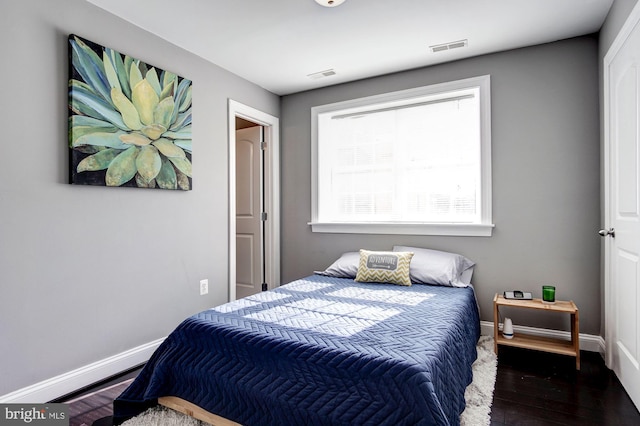 bedroom with dark hardwood / wood-style flooring