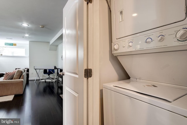 laundry area featuring dark hardwood / wood-style flooring and stacked washer and dryer