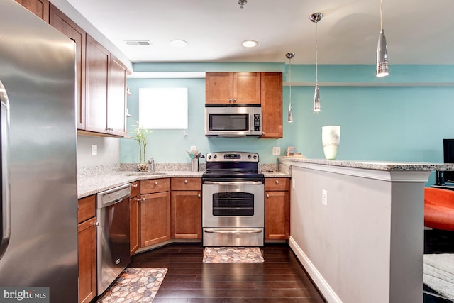 kitchen featuring kitchen peninsula, light stone countertops, dark hardwood / wood-style flooring, stainless steel appliances, and decorative light fixtures