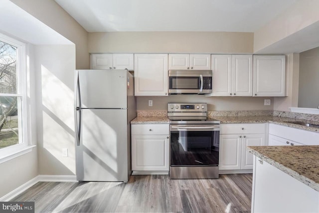 kitchen featuring white cabinets, sink, appliances with stainless steel finishes, and light hardwood / wood-style flooring