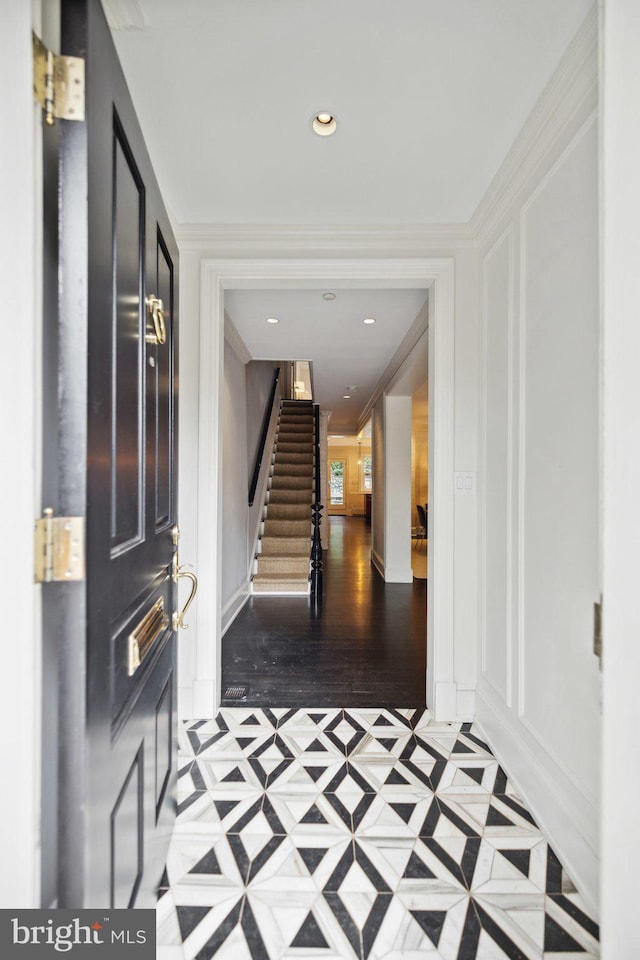 entrance foyer with crown molding and light hardwood / wood-style flooring