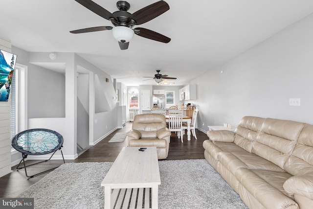 living room featuring ceiling fan and dark wood-type flooring