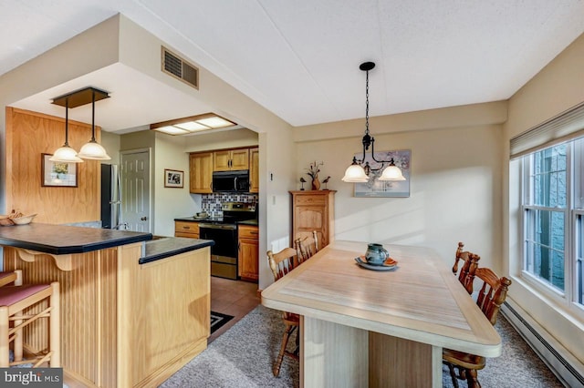 dining space featuring an inviting chandelier and a baseboard heating unit