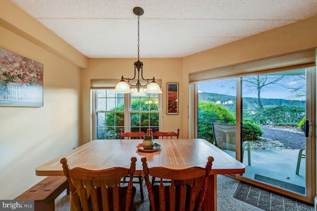 carpeted dining room featuring a mountain view and a chandelier