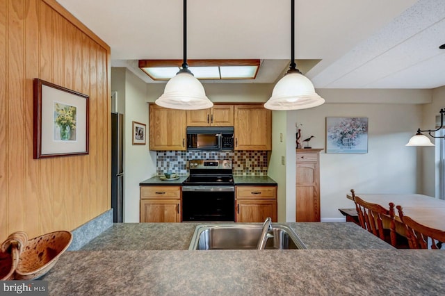 kitchen with tasteful backsplash, sink, decorative light fixtures, and appliances with stainless steel finishes