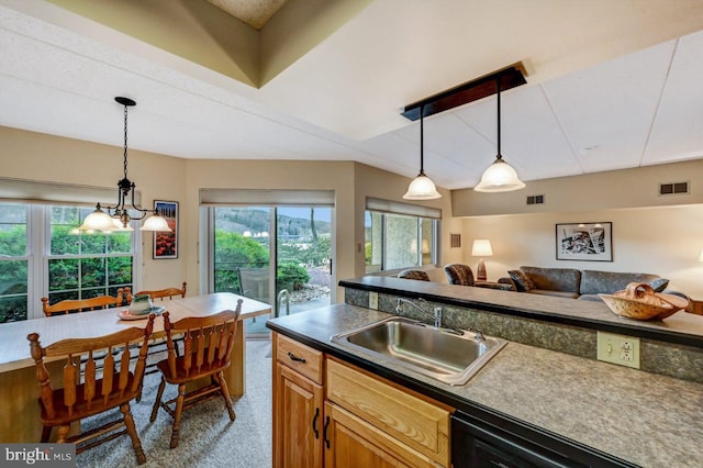 kitchen with sink, carpet, a healthy amount of sunlight, and decorative light fixtures