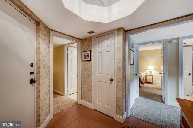 hall with tile patterned floors