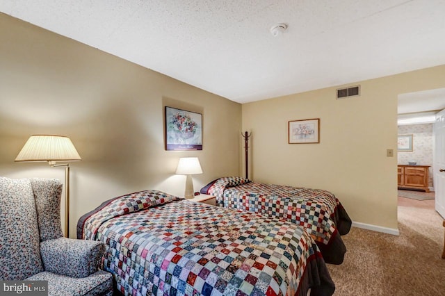 carpeted bedroom with a textured ceiling and connected bathroom