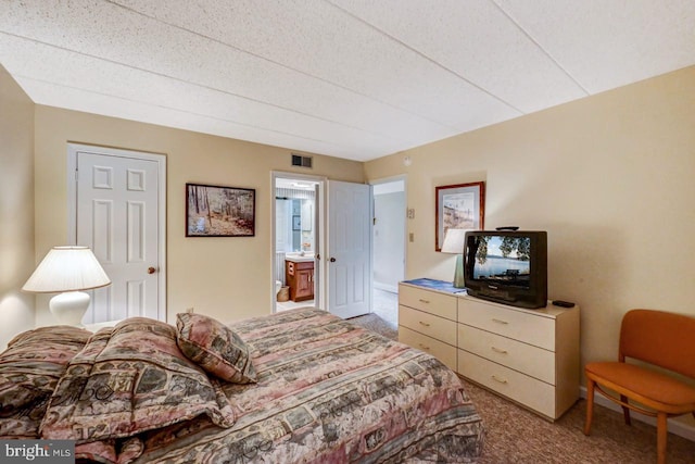 carpeted bedroom featuring ensuite bath