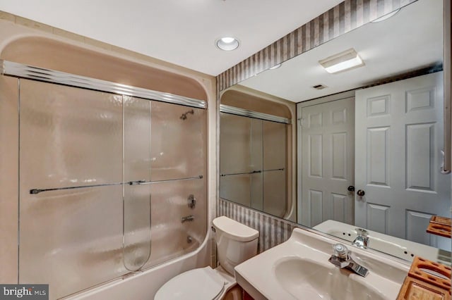 full bathroom featuring vanity, enclosed tub / shower combo, and toilet