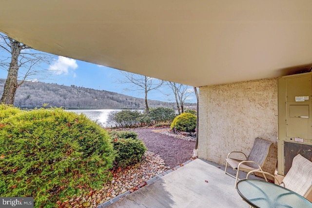 view of patio / terrace with a water and mountain view