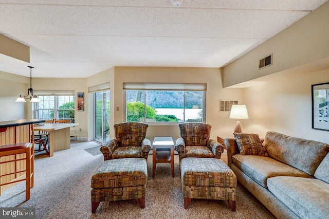 carpeted living room featuring a textured ceiling and a notable chandelier