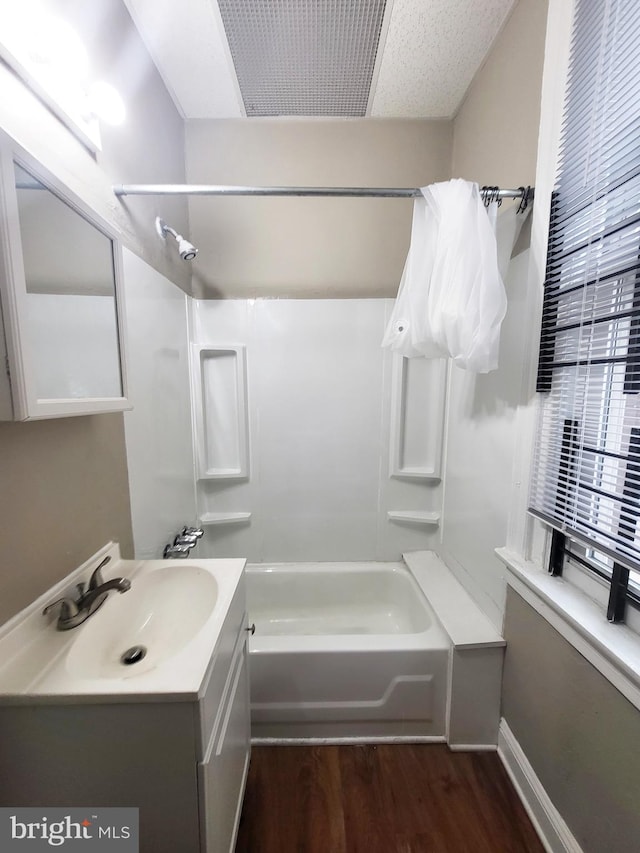 bathroom with hardwood / wood-style floors, vanity, and shower / bath combination