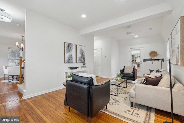 living room with light hardwood / wood-style flooring and ceiling fan with notable chandelier