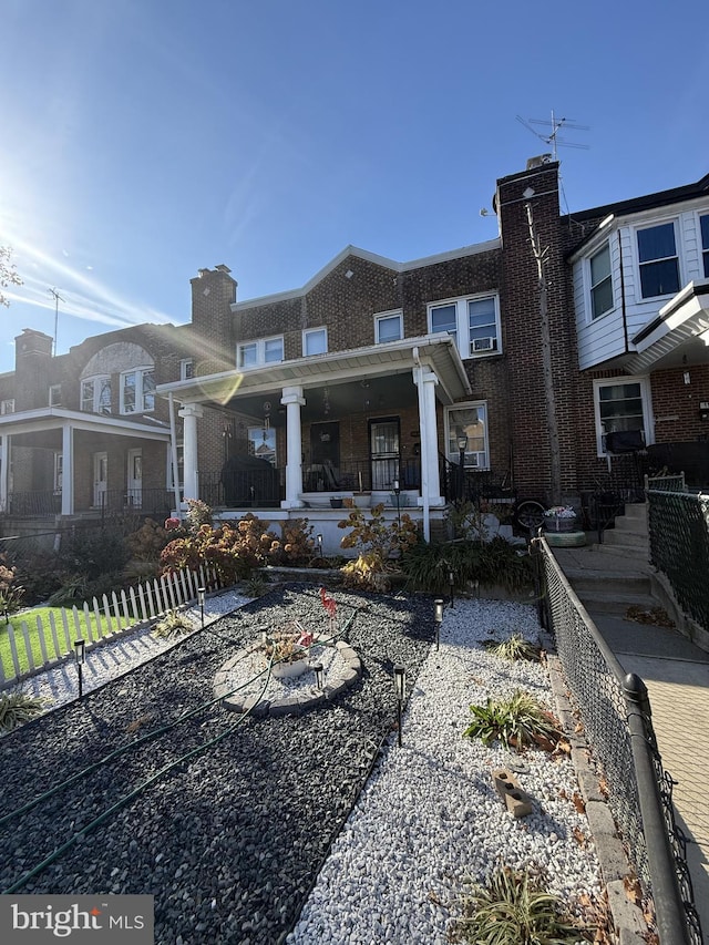 back of property featuring a porch and an outdoor fire pit