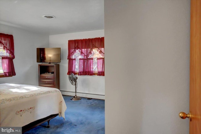 bedroom featuring carpet flooring, multiple windows, and a baseboard heating unit