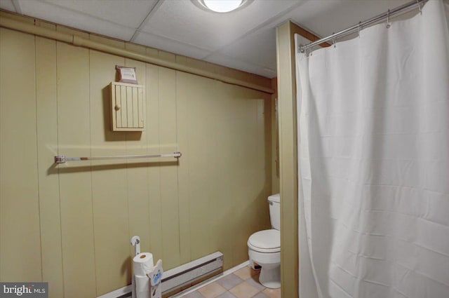 bathroom featuring a paneled ceiling, wood walls, toilet, and baseboard heating